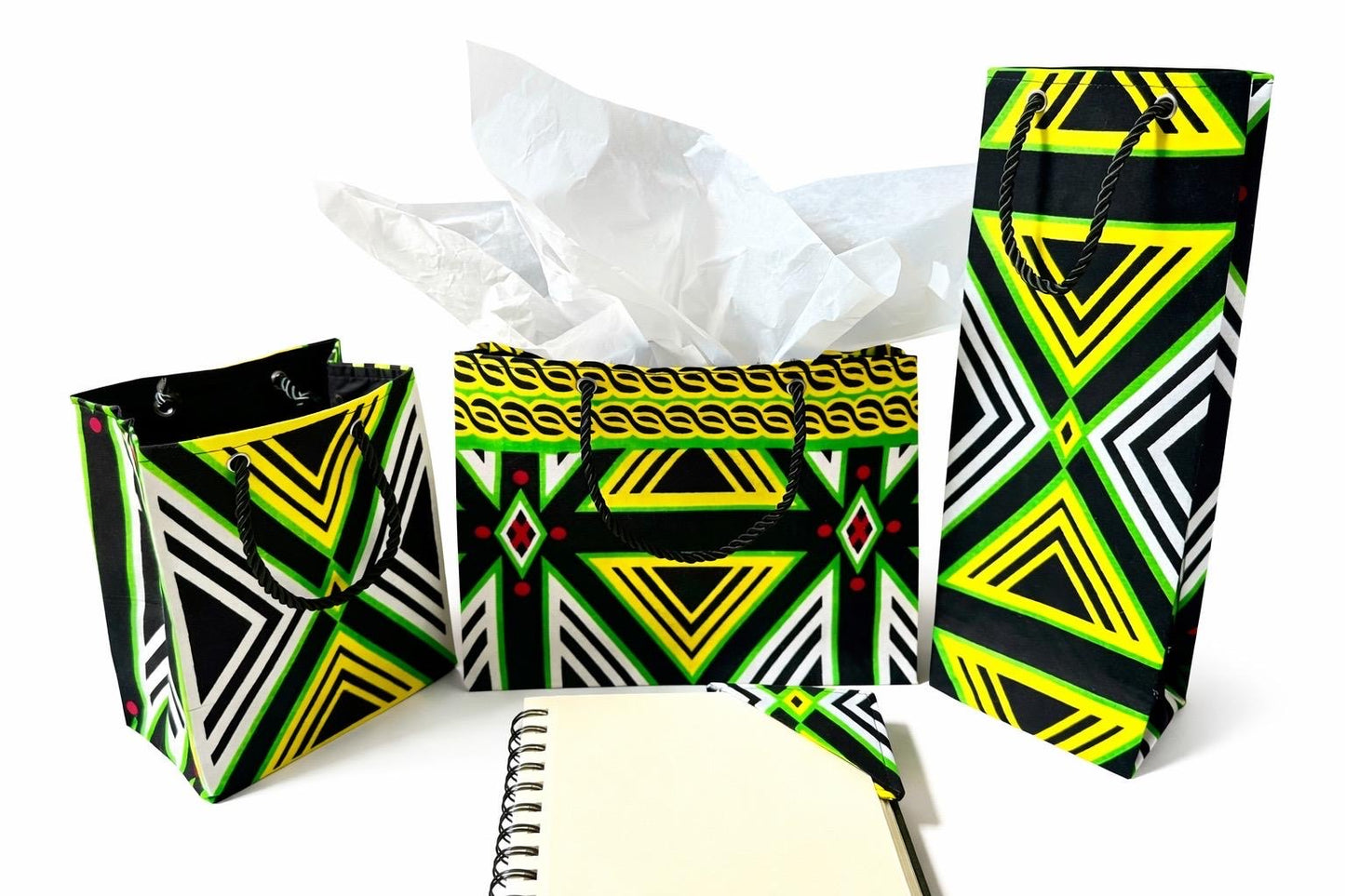 Black, green, yellow, & white small horizontal bag, wine bag, corner bookmark, & extra small gift bag on a white background