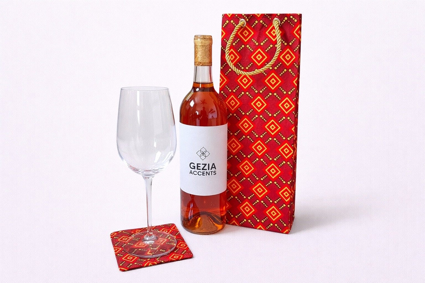 Maroon, red, gold, & black wine bag & coaster on a white background
