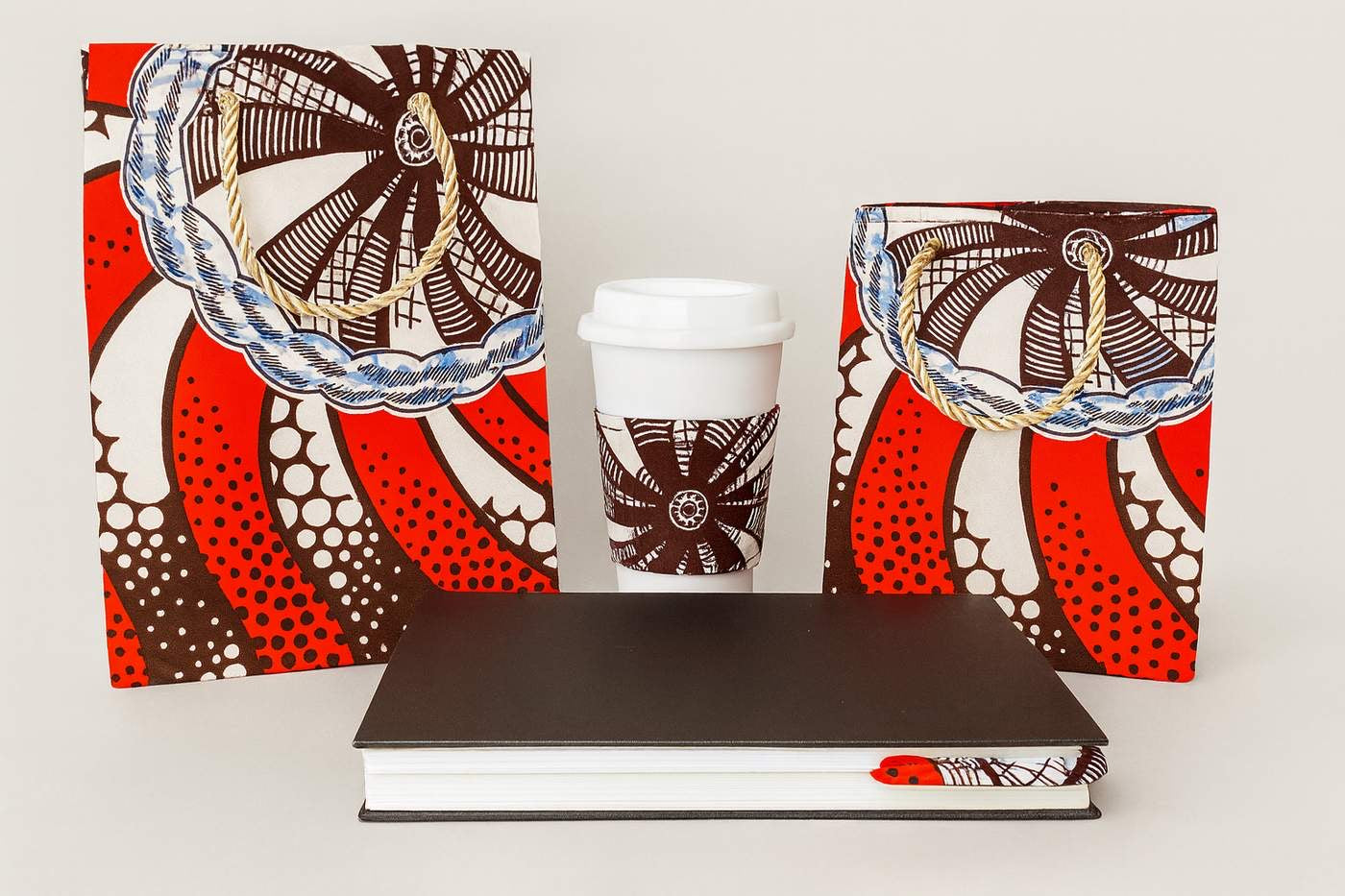 red, brown, & white extra small gift bag, small square gift bag, & cup sleeve, & corner bookmark on a white background