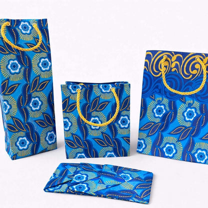 Dark blue, blue, white, & gold medium bag, extra small bag, wine bag, four coasters on a white background
