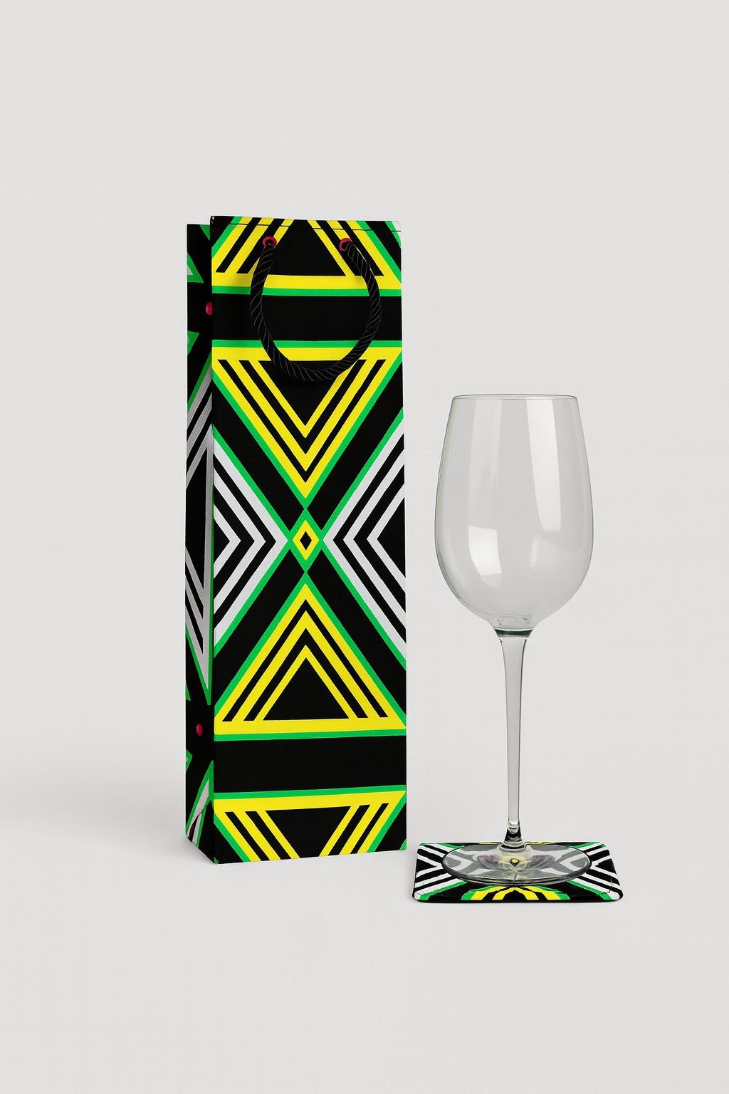 Black, white, yellow, & green wine bag, & coaster on a white background