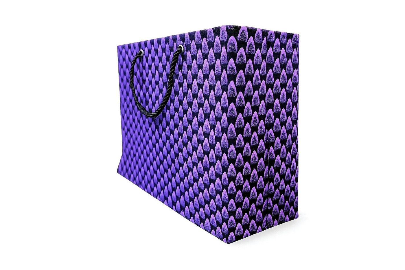 Side view of a purple and black patterned horizontal gift bag with black handle on a white background